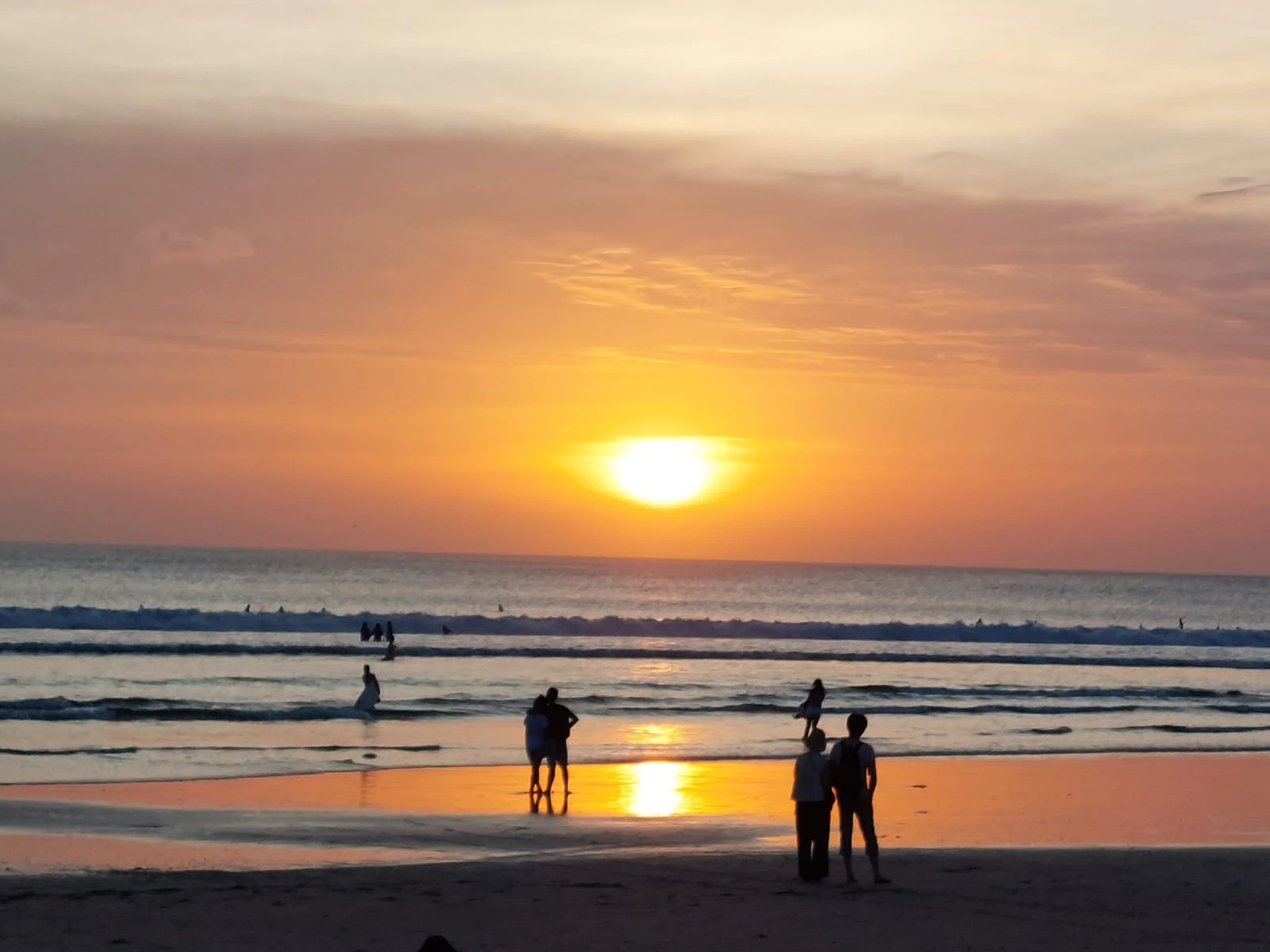 Tramonto sul mare, con persone sulla spiaggia